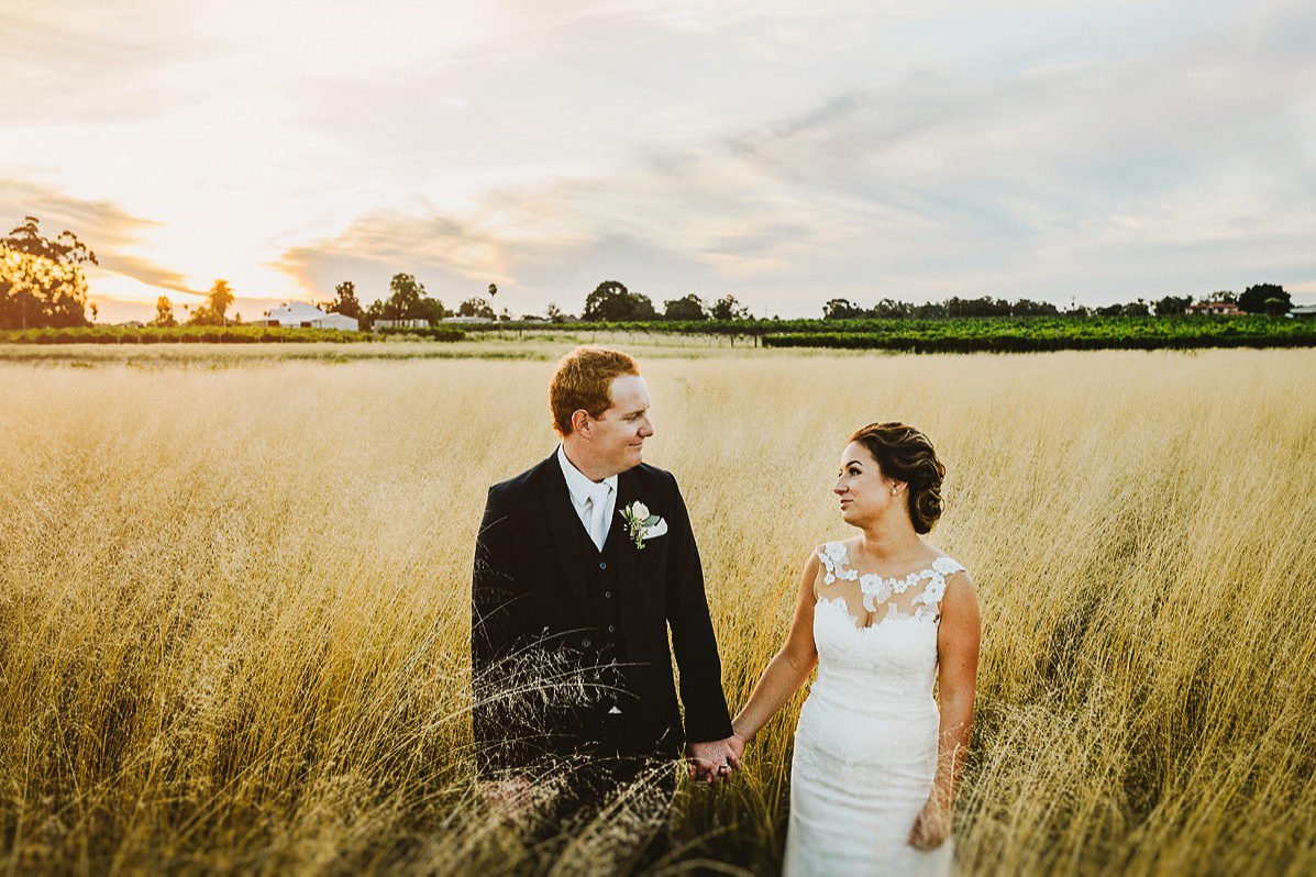 bride and groom looking at each other in open fields